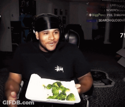 Man In Black Stussy Shirt Holding Broccoli Tray GIF