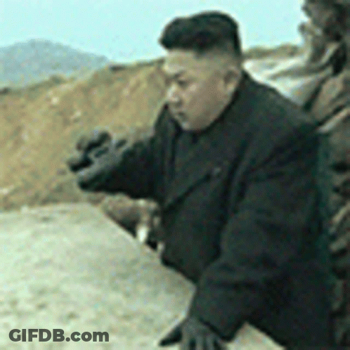 Man In Black Suit And Gloves Standing In Dirt GIF