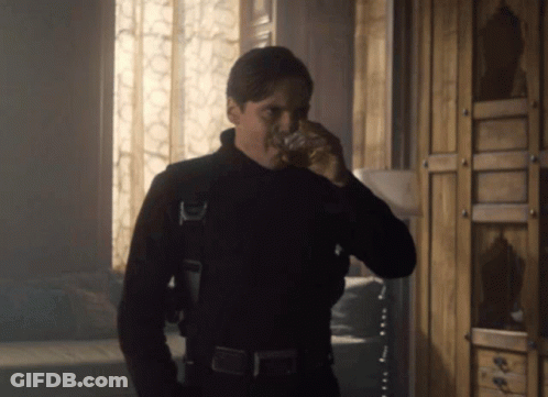 Man In Black Suit Drinking From Glass GIF