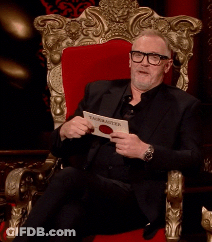 Man In Black Suit Holding Taskmaster Paper GIF
