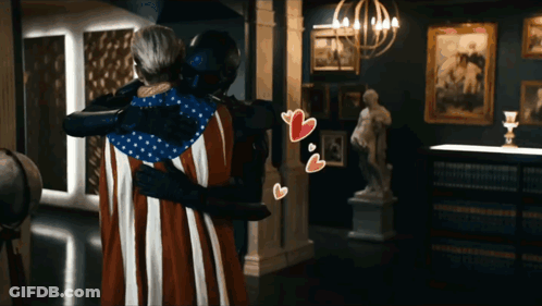Man In Black Suit Hugging Woman In American Flag Costume GIF