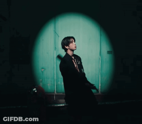 Man In Black Suit In Front Of Green Door GIF