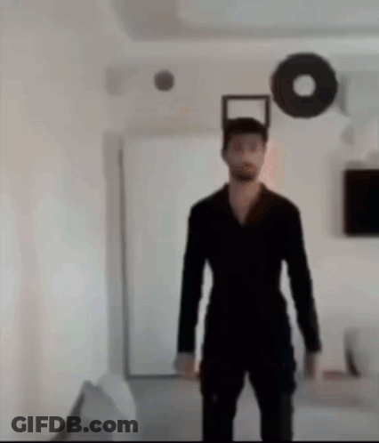 Man In Black Suit In Living Room GIF