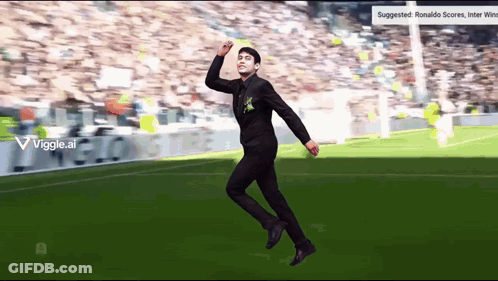 Man In Black Suit Jumping On Soccer Field GIF