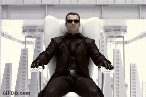 Man In Black Suit Sitting On White Chair GIF