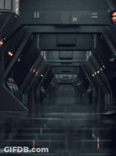 Man In Black Suit Standing In Hallway With Hands In Pockets GIF