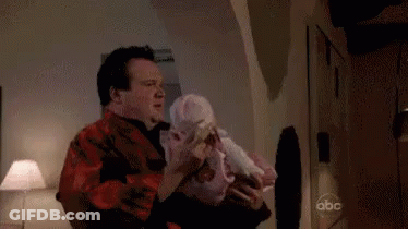 Man In Black Suit Standing In Living Room GIF
