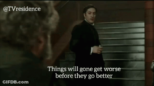 Man In Black Suit Standing Next To Woman Saying Things Will Get Worse Before They Get Better GIF