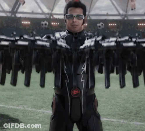 Man In Black Suit With F Holding Guns GIF