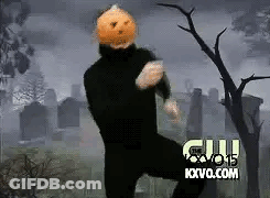 Man In Black Suit With Pumpkin Head Dancing In Cemetery GIF