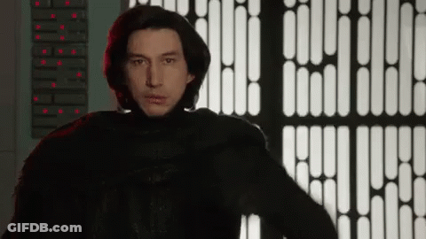 Man In Black Suit With Red Light Behind GIF