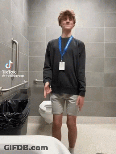 Man In Black Sweater And Grey Shorts Beside Toilet GIF