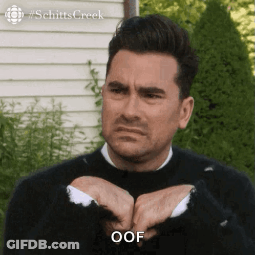 Man In Black Sweater And White Shirt Saying Oof GIF