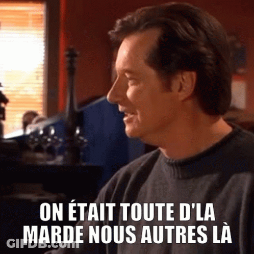 Man In Black Sweater At Table With French Caption GIF