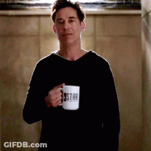 Man In Black Sweater Holding Coffee Mug Saying Star GIF
