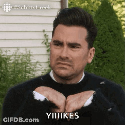 Man In Black Sweater Making Funny Face Says Yiiikes GIF