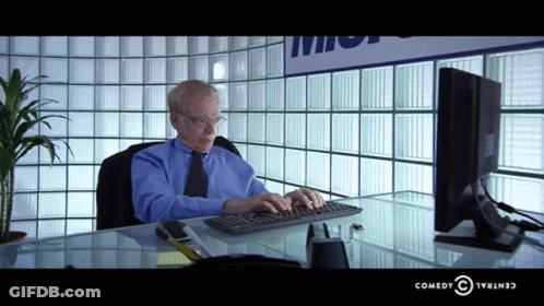 Man In Black Sweater Next To Woman In Chair GIF