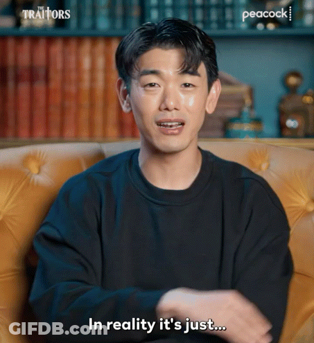 Man In Black Sweater On Yellow Couch Saying In Reality It's Just GIF