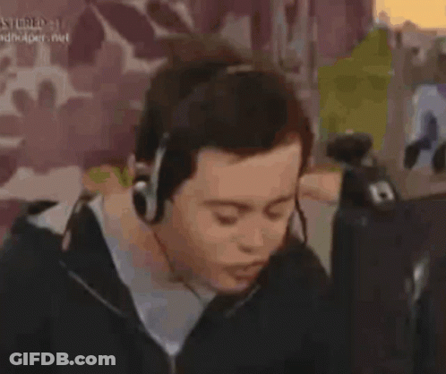 Man In Black Sweater Sitting In Front Of Purple Wall GIF
