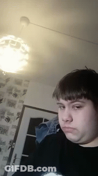 Man In Black Sweater With Letter T Looking At Camera GIF