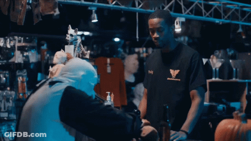 Man In Black T-Shirt With Eagle Talks To Another Man GIF