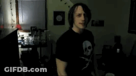 Man In Black T-Shirt With Skull In Dark Room GIF