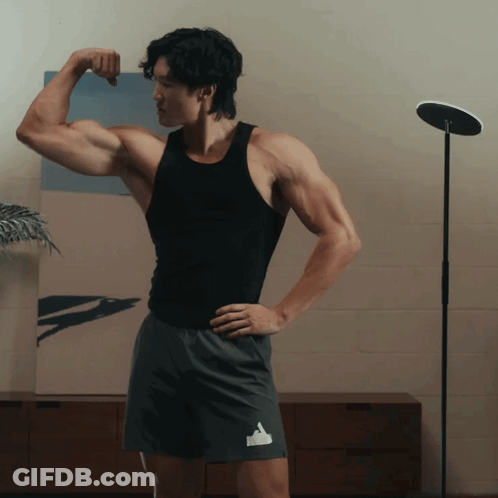 Man In Black Tank Top Flexing Arm GIF