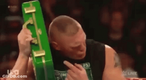Man In Black Tank Top Holding Green Briefcase Over Head GIF
