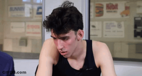 Man In Black Tank Top Sitting By Burger King Sign GIF