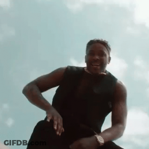 Man In Black Tank Top Sitting On Rock GIF