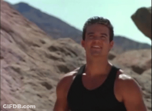 Man In Black Tank Top Smiling In Desert GIF