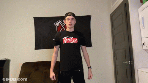 Man In Black Tribe Shirt In Front Of Black Flag GIF