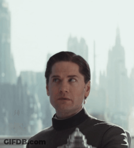 Man In Black Turtleneck Looking Out Window With City GIF