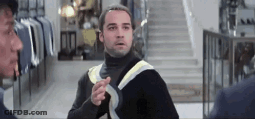 Man In Black Turtleneck Pointing At Another Man GIF