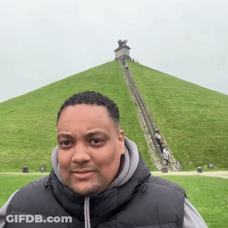 Man In Black Vest On Grassy Hill GIF