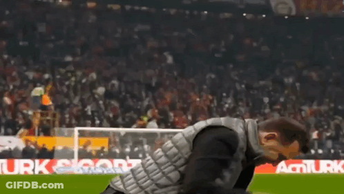 Man In Black Vest Walking On Soccer Field GIF