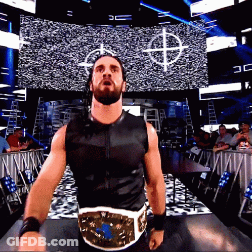 Man In Black Vest With Gold Belt Before Screen With Letter D GIF
