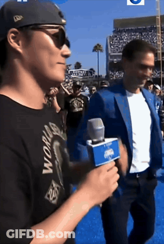 Man In Black World Shirt Holding Microphone GIF