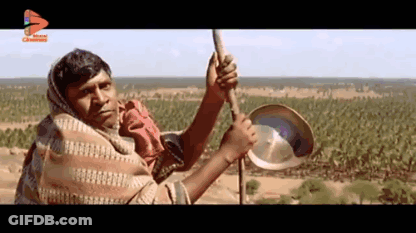 Man In Blanket Holding Pan And Stick GIF