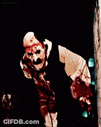 Man In Bloody Clown Costume In Dark Room GIF