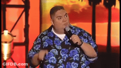 Man In Blue And Black Floral Shirt Holding Microphone Making Funny Face GIF