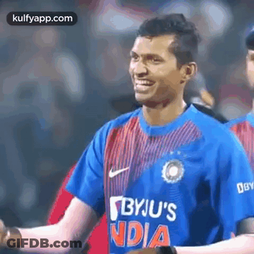 Man In Blue And Red Striped Shirt Smiling On Field GIF