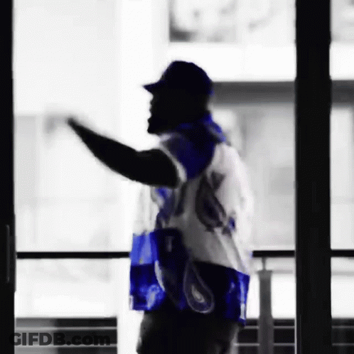 Man In Blue And White Jersey Waving By Window GIF