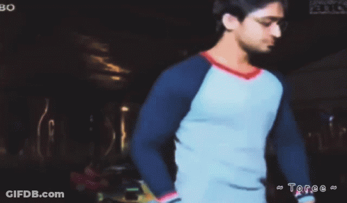 Man In Blue And White Shirt In Dark Room With Toree GIF