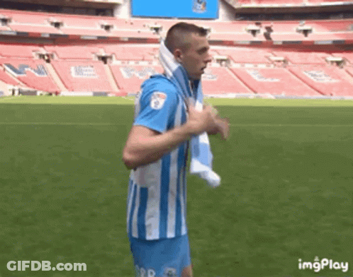 Man In Blue And White Striped Shirt Running On Soccer Field With Towel GIF