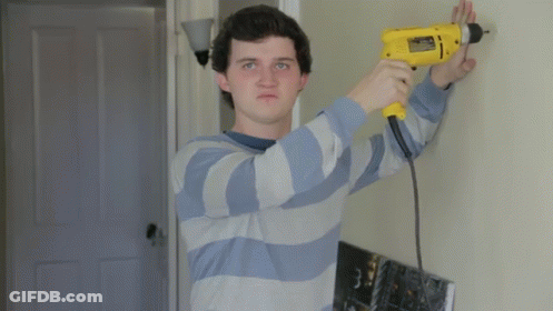 Man In Blue And White Striped Shirt Using Yellow Drill GIF