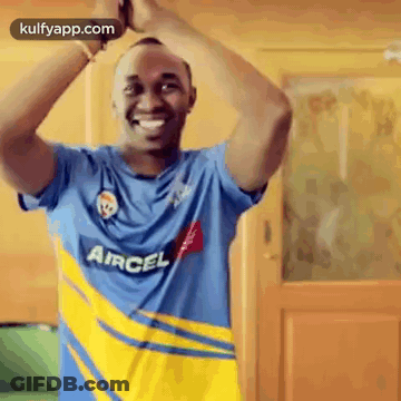 Man In Blue And Yellow Aircel Shirt Standing In Front Of Door GIF