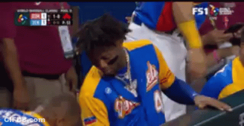 Man In Blue And Yellow Jersey Sitting In Dugout GIF
