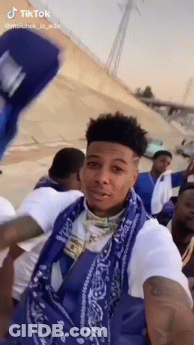 Man In Blue Bandana And White Shirt Standing Before Crowd GIF