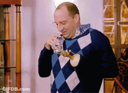 Man In Blue Checkered Sweater Drinking From Glass GIF